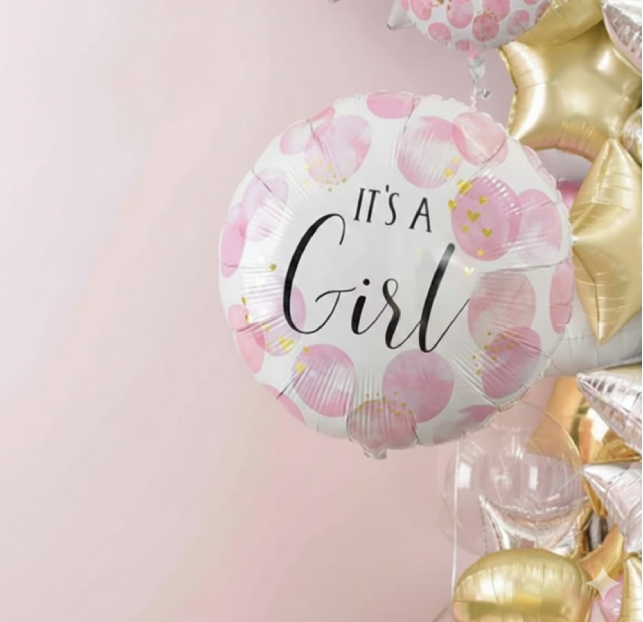 A balloon with 'It's a Girl' text in pink and gold decor.