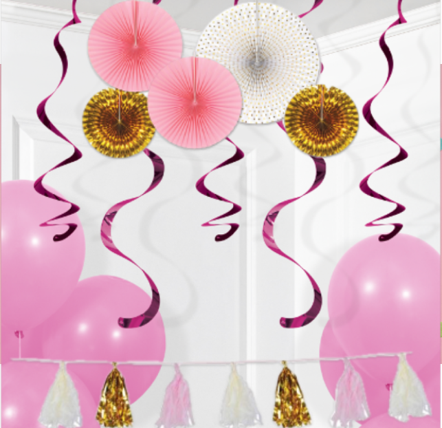 Pink and gold birthday decorations with balloons and streamers.